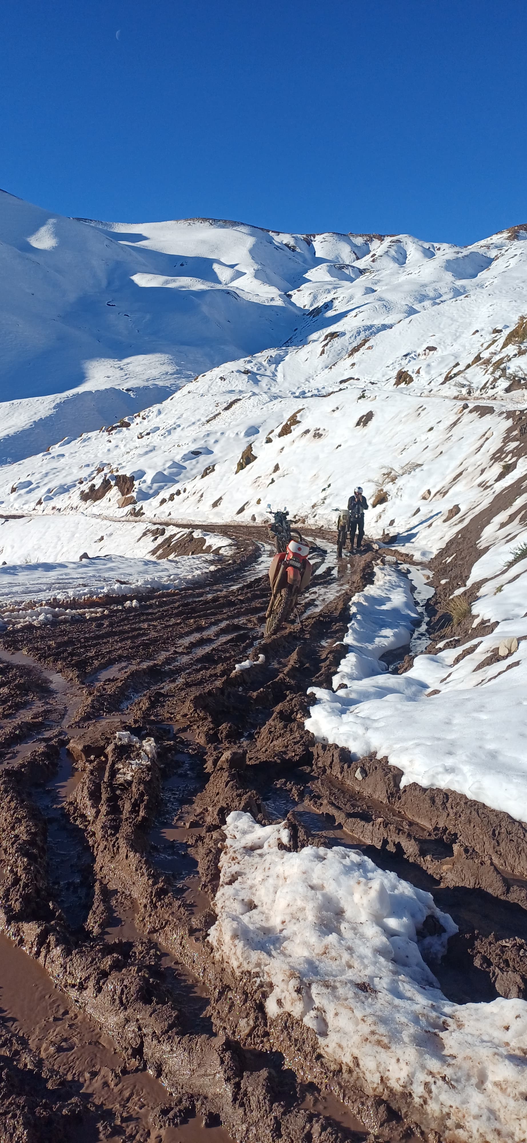 Gravel road crossing a high-mountain landscape in western Argentina.