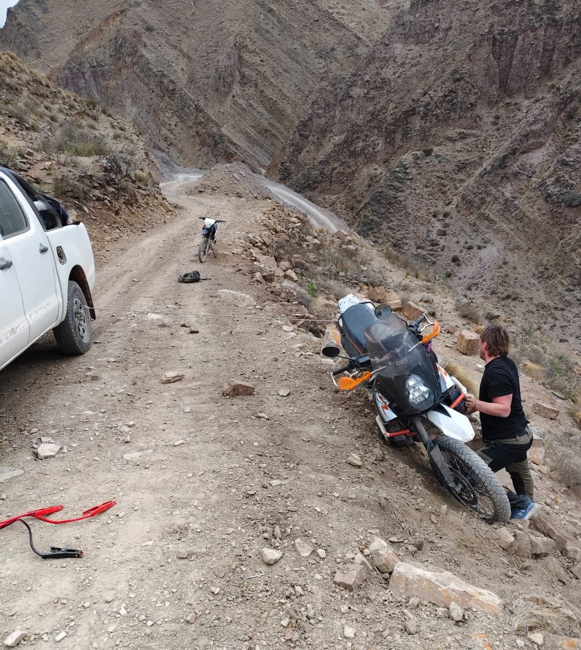 Piloto e moto parados em uma quebrada de altitude do norte argentino.