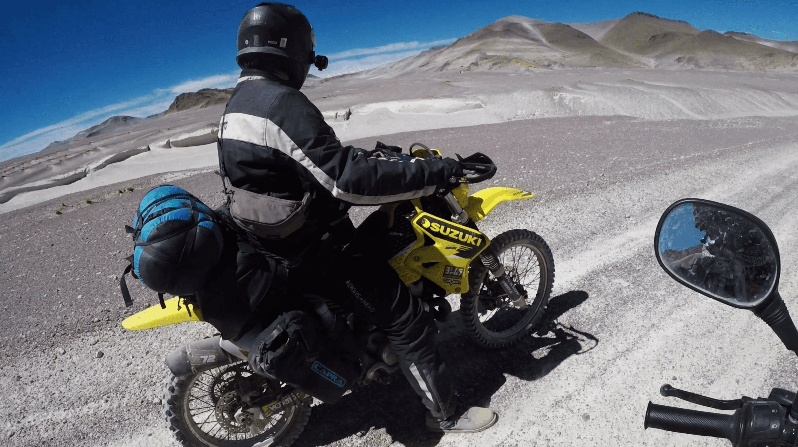 Rider crossing volcanic terrain during a Catamarca test ride.