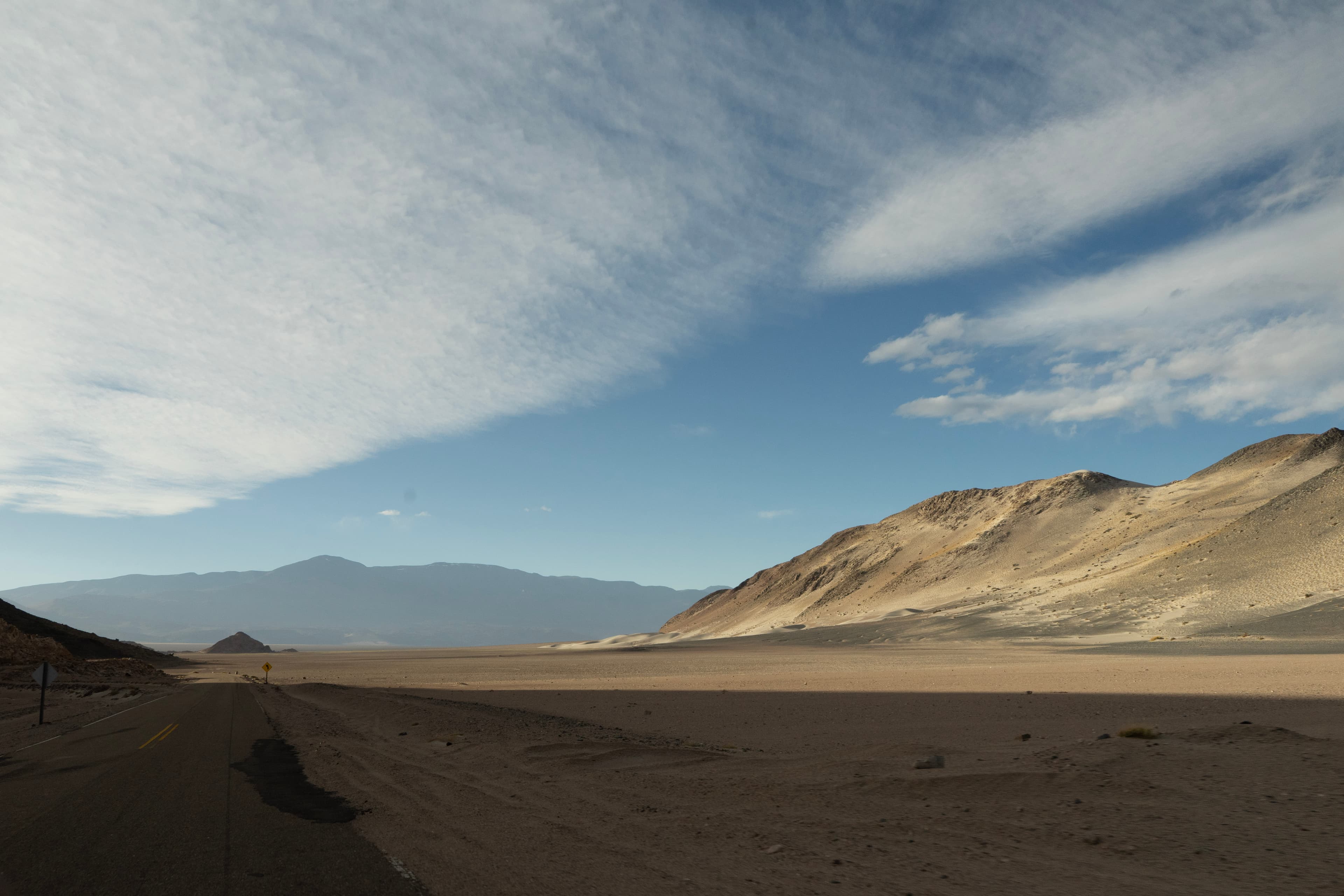 Open road between salt flats and volcanoes